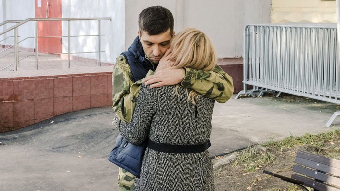 Ein Soldat umarmt seine Frau