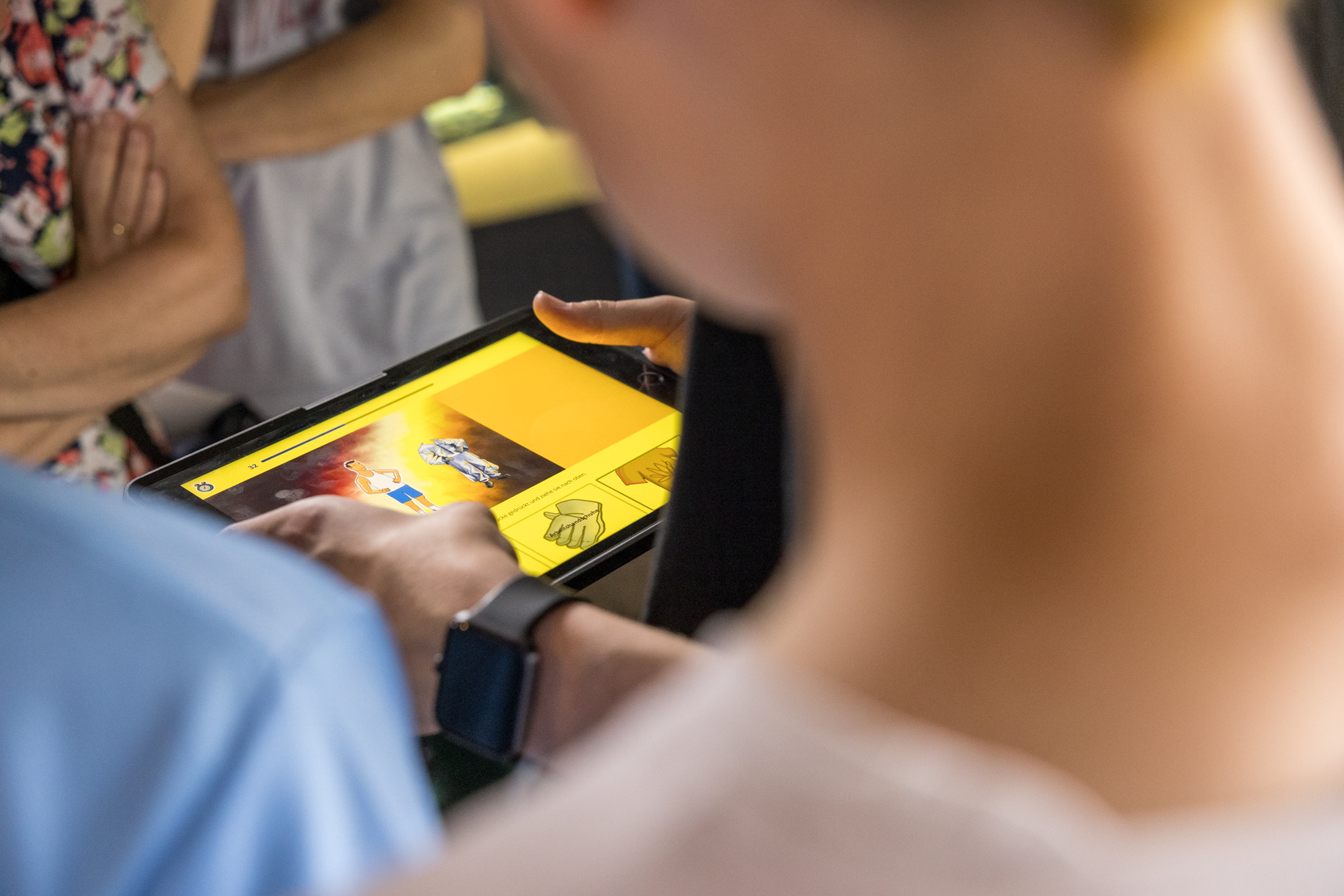 Hände halten ein Tablet mit der Museumsapp.