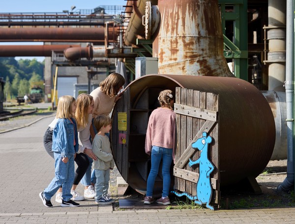 Kinder auf der Schatzsuche in einer der Röhren der blauen Museumsratte.