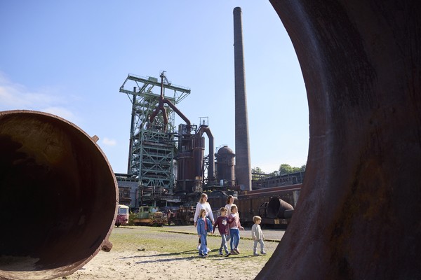 Blick auf den Hochofen, vor dem eine Gruppe läuft