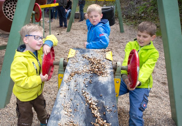 Drei Kinder spielen im Sandkasten des Spielplatzes