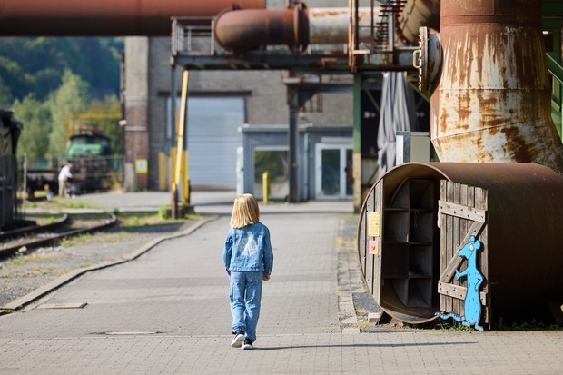 Mädchen läuft neben einem Holzfass mit Rattenaufsteller.
