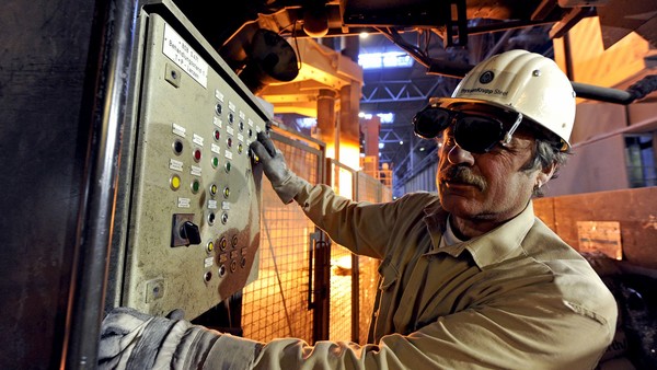 Ein Arbeiter von ThyssenKrupp Steel steht vor dem Bedienfeld einer Maschine