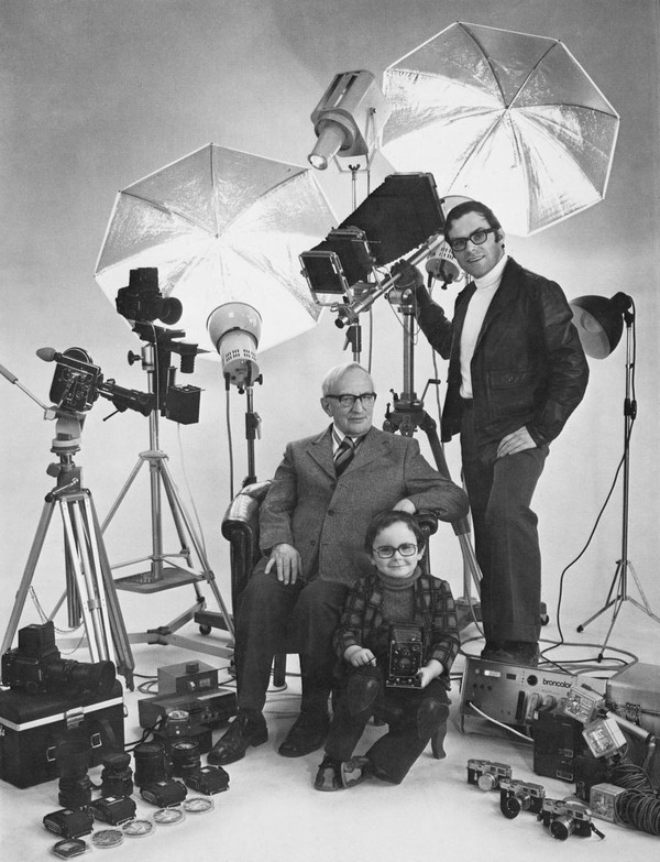 Vater, Sohn und Enkelsohn posieren für ein gemeinsames Foto im Fotoatelier.